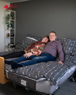 Janna Kramer (66) leeft sinds 2022 met ALS. Lopen gaat niet meer, maar de liefde tussen haar en haar man Tom staat nog altijd recht overeind. Dankzij een couplebed, dat naadloos aansluit op haar zorgbed, kunnen ze elke nacht gewoon samen slapen. Dicht tegen elkaar aan, zoals al bijna 40 jaar.
“ALS dwingt je om zoveel los te laten. Maar samen slapen, samen wakker worden… dat houdt ons leven herkenbaar. Dit bed is er niet alleen voor mij, maar voor ons.” Bij Stichting ALS op de Weg geloven we dat hulpmiddelen niet alleen praktisch moeten zijn, maar ook menselijk. Want je minder ziek en minder alleen voelen, dat is belangrijk. 🧡
#ALSopdeWeg #StichtingALS #StopALS #kwaliteitvanleven #couplebed #ALSHulpmiddelen